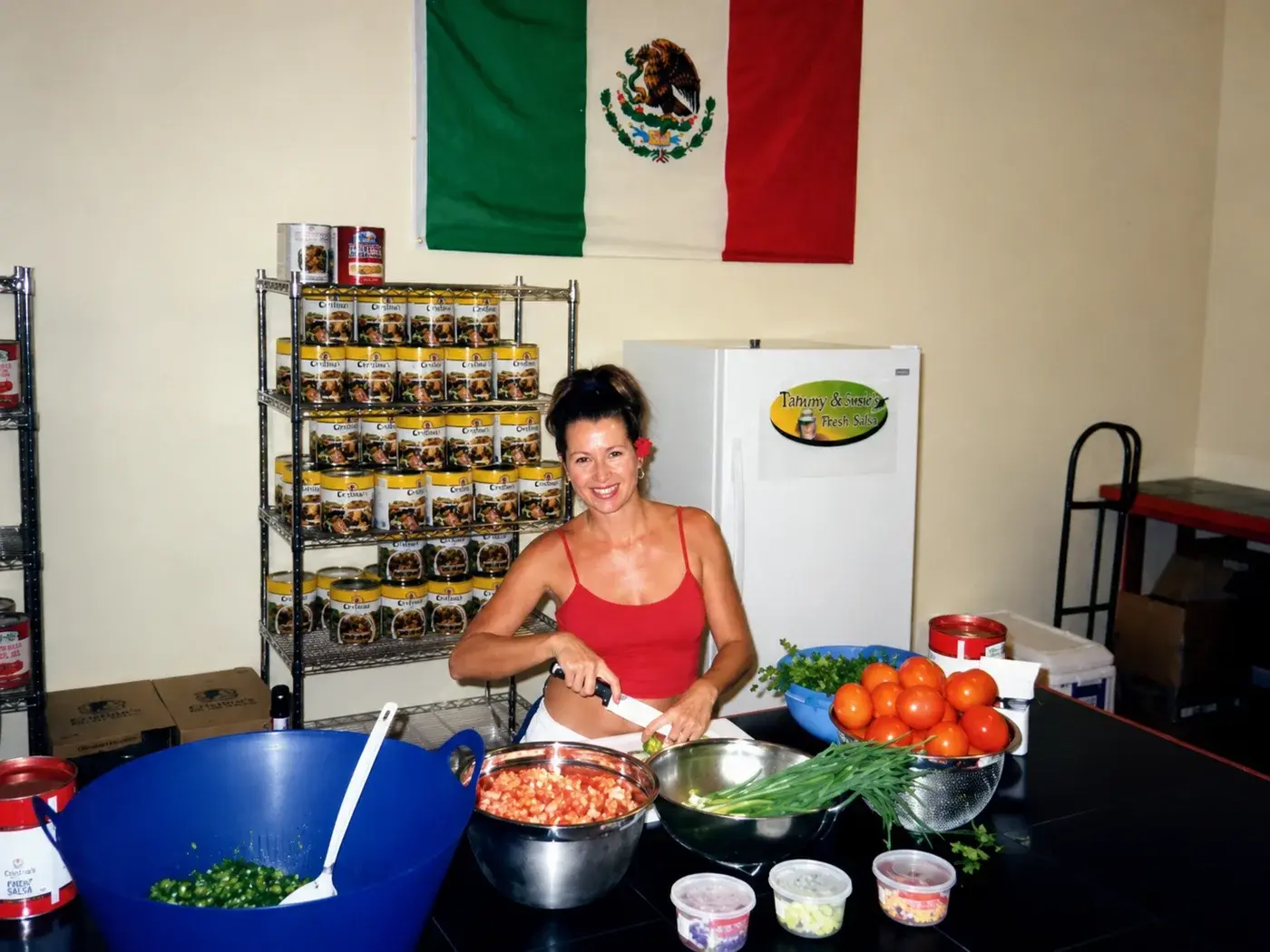 Tiffany Smith chopping tomatoes and green onion in the original commercial kitchen
